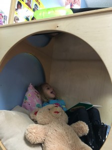 Lily uses the relaxing retreat in her preschool classroom for some quiet alone time after drop-off. She loves snuggling the teddy bear, reading a book and making funny faces in the mirror on top.