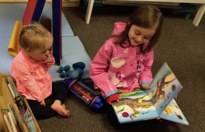 Evie reads to Juno in her classroom at Growing Together Preschool.